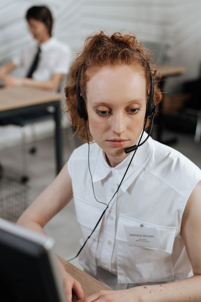 Focused call center agent with headset working in a modern office setting.