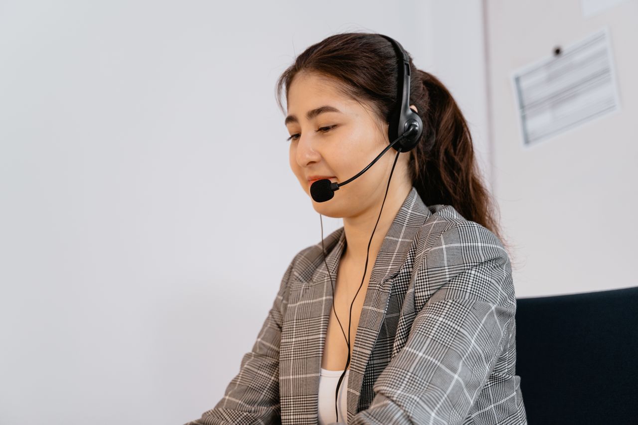 services-header Professional woman providing customer support, wearing headset in office.